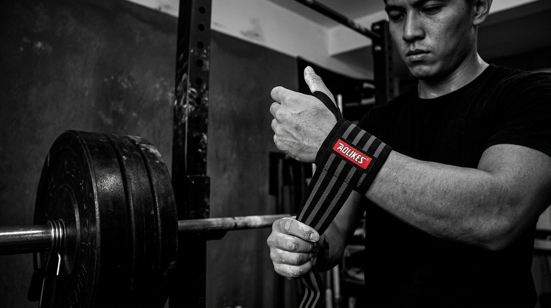 Lifter wrapping their wrist with Becketts Active wrist wraps before a heavy lift