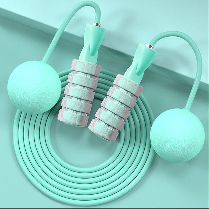 Close-up of green colored weighted handles on dual-use jump rope for added resistance and arm toning.