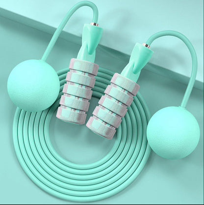 Close-up of green colored weighted handles on dual-use jump rope for added resistance and arm toning.