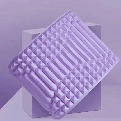 Contoured light purple colored yoga pillow with ergonomic design for waist and lower-back support during stretching.