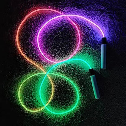 Neon luminous (Glow-in-the-dark) jump rope glow sticks in pink, green, and red on a dark surface.