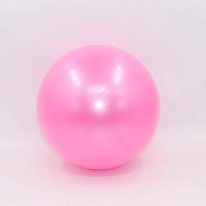 Pink colored portable pilates mini ball for core strengthening, balance training, and yoga exercises.