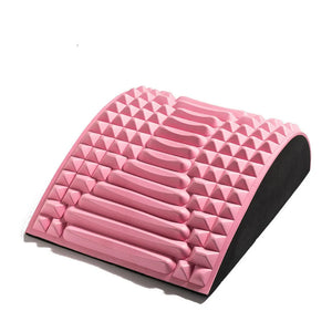 Contoured pink colored yoga pillow with ergonomic design for waist and lower-back support during stretching.