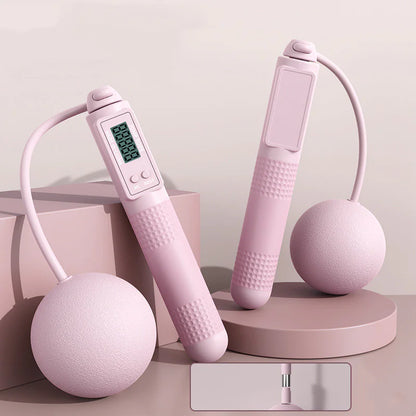 Smart jump rope with big pink balls and digital display on a light blue background.