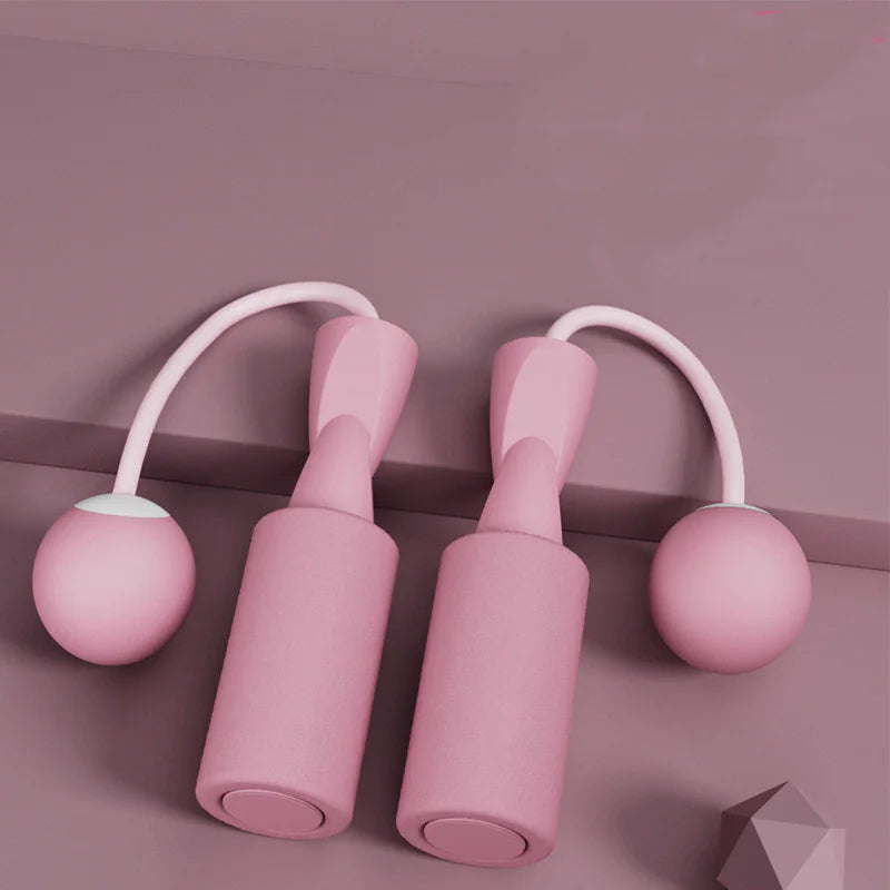 Smart jump rope with pink balls and digital display on a light blue background.