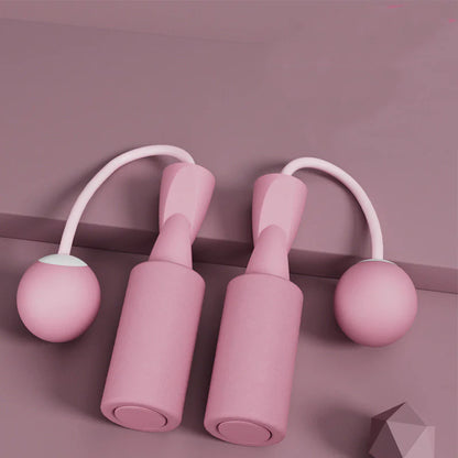 Smart jump rope with pink balls and digital display on a light blue background.