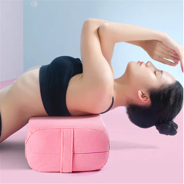 Supported backbend pose with yoga pillow providing lumbar support and spinal alignment.