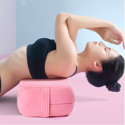 Supported backbend pose with yoga pillow providing lumbar support and spinal alignment.