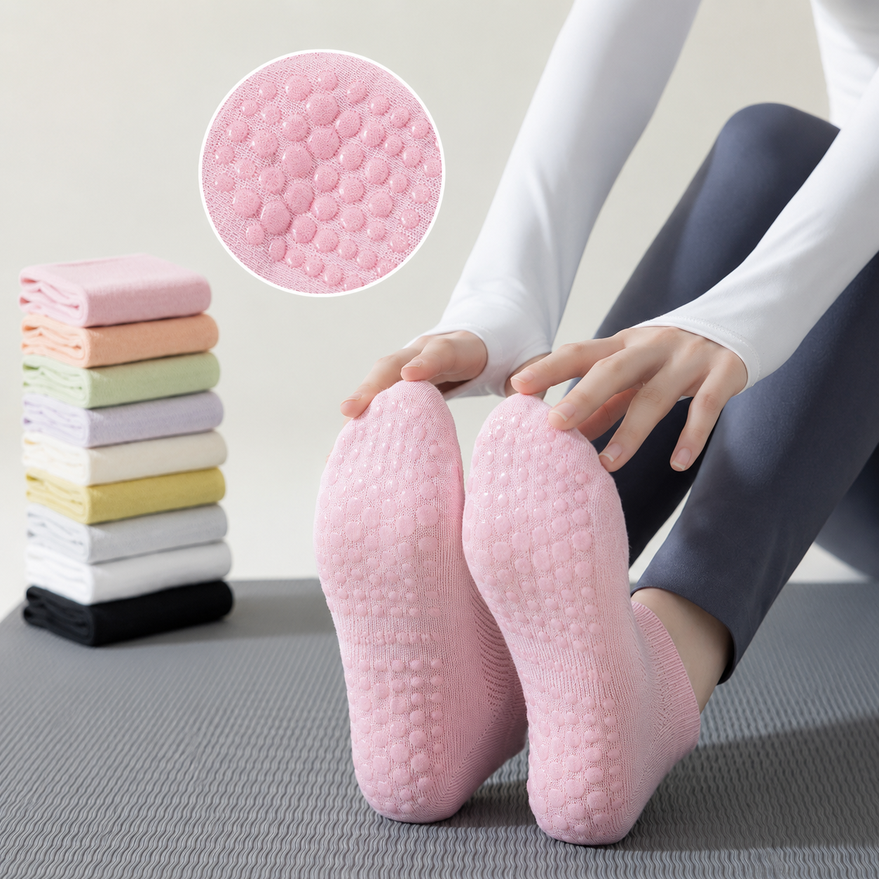 Woman wearing pink non-slip Pilates socks with silicone grip soles while sitting on a yoga mat indoors, showcasing breathable mesh fabric and traction for yoga and home workouts.